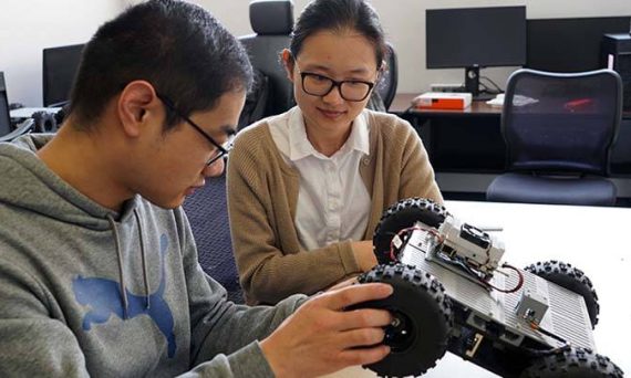 Engineering student Baoqian Wang (left) works on an autonomous vehicle with Professor Junfei Xie at San Diego State University